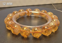 將影片載入圖庫檢視器並播放，本段影片完整展示黃水晶手鍊 12MM 16粒 的黄金色澤與晶體細節。
