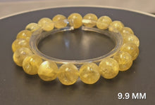 將影片載入圖庫檢視器並播放，本段影片完整展示黄金鋰雲母水晶手鍊 9.9MM 19粒 的黄金色澤與晶體細節。

